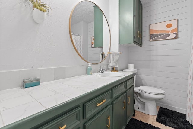 bathroom with vanity, toilet, a textured ceiling, and tile patterned floors