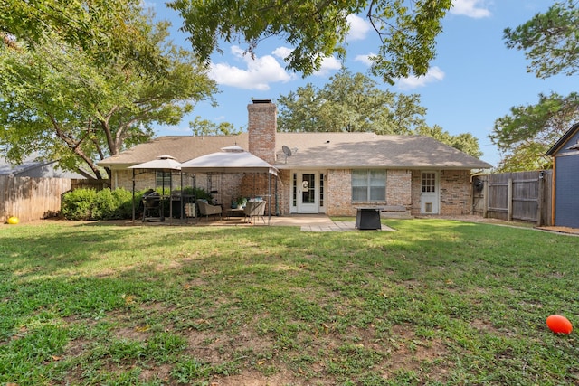 rear view of house with a lawn and a patio area