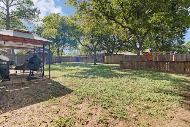 view of yard featuring a playground, a gazebo, and a patio area