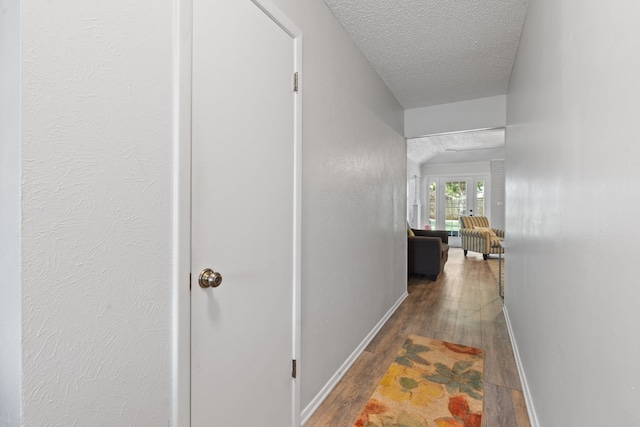 hall featuring hardwood / wood-style flooring and a textured ceiling