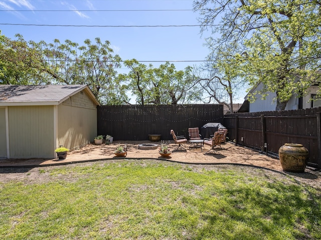 view of yard with a storage unit, a patio area, and a fire pit