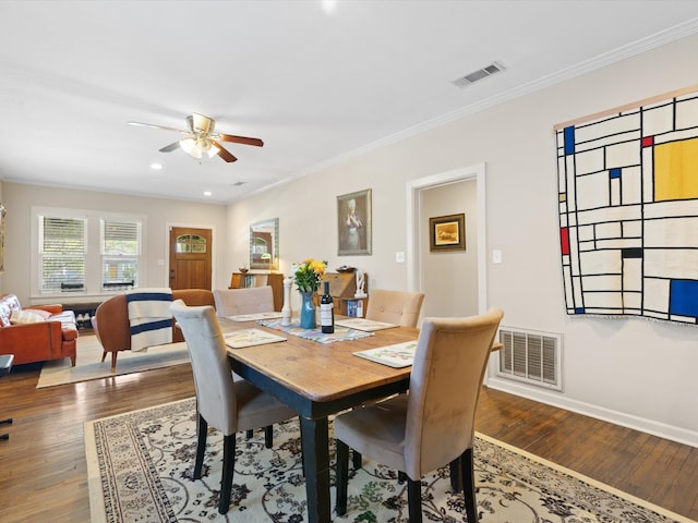 dining space with crown molding, ceiling fan, and wood-type flooring