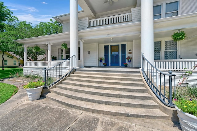 property entrance featuring ceiling fan, a balcony, and a porch