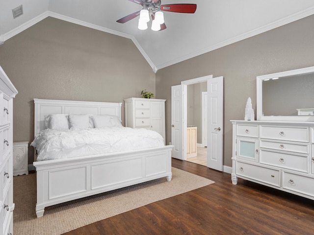 bedroom with dark hardwood / wood-style flooring, vaulted ceiling, ornamental molding, and a fireplace