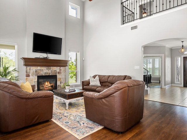 living room with crown molding, a towering ceiling, a notable chandelier, sink, and light hardwood / wood-style floors