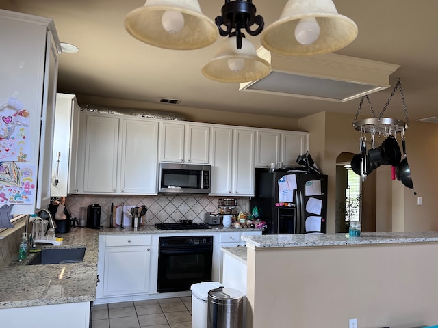 kitchen with white cabinets, tasteful backsplash, light stone countertops, black appliances, and sink