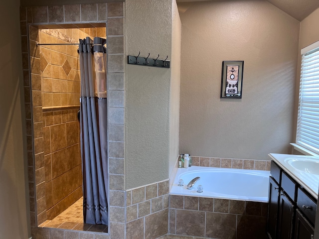 bathroom featuring vanity and independent shower and bath