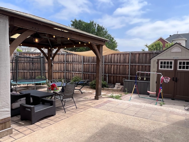 view of patio with a gazebo, a trampoline, and a storage shed