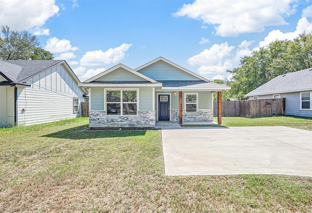 view of front of property featuring stone siding, fence, a front lawn, and a porch