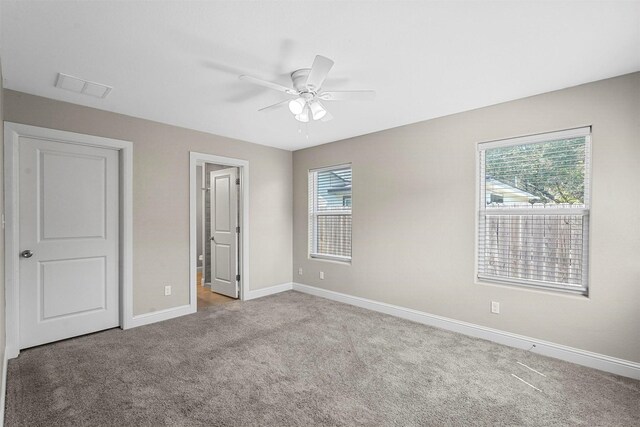 unfurnished bedroom featuring a ceiling fan, carpet, baseboards, and visible vents
