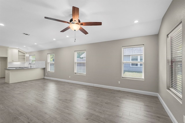 unfurnished living room with vaulted ceiling, ceiling fan, and hardwood / wood-style flooring