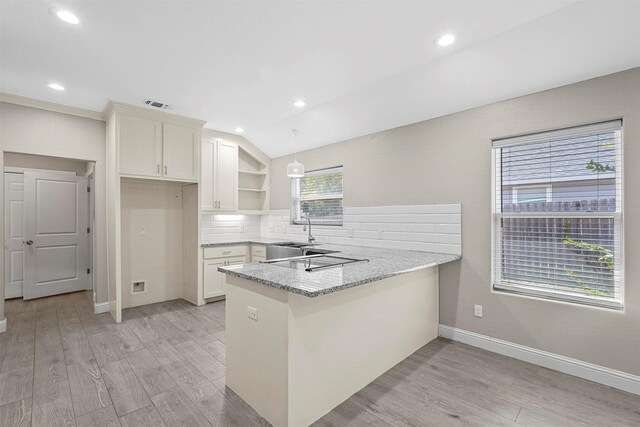 kitchen with light wood-type flooring, a peninsula, open shelves, and decorative backsplash