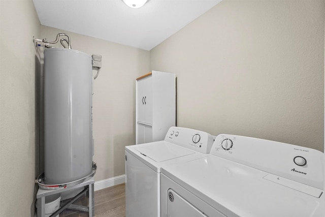 clothes washing area featuring washer and clothes dryer, hardwood / wood-style floors, and water heater