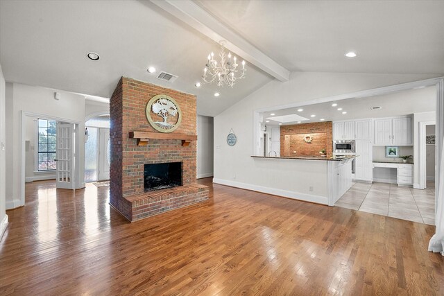 kitchen with white cabinets, decorative light fixtures, a kitchen island, and stainless steel appliances