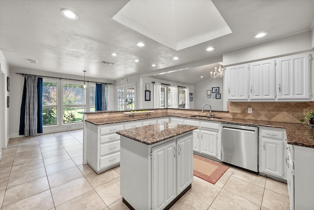 kitchen featuring dishwasher, white cabinetry, a textured ceiling, a kitchen island, and kitchen peninsula