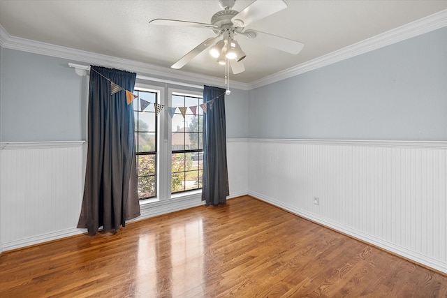 spare room featuring hardwood / wood-style flooring, plenty of natural light, crown molding, and ceiling fan