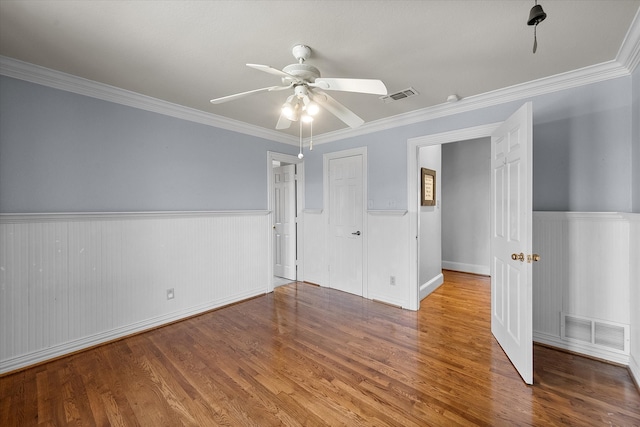 unfurnished bedroom featuring wood-type flooring, ceiling fan, and crown molding