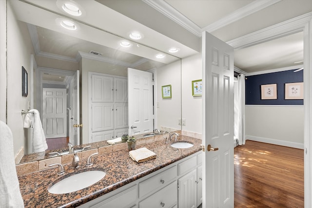 bathroom featuring hardwood / wood-style floors, vanity, and ornamental molding