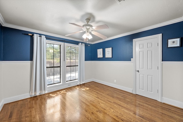 unfurnished room featuring hardwood / wood-style floors, a textured ceiling, ceiling fan, and crown molding