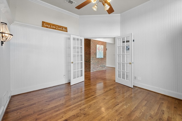 spare room featuring hardwood / wood-style flooring, french doors, ceiling fan, and ornamental molding