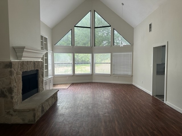 unfurnished living room with a fireplace, plenty of natural light, dark hardwood / wood-style flooring, and high vaulted ceiling