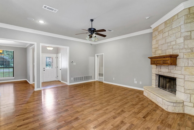 unfurnished living room featuring ceiling fan, light wood-type flooring, ornamental molding, and a healthy amount of sunlight