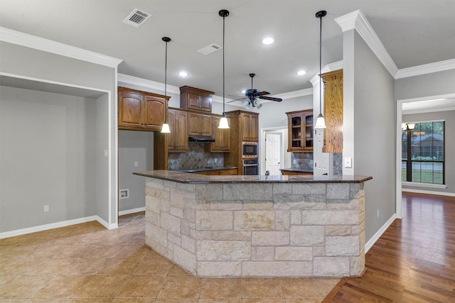 kitchen with light hardwood / wood-style floors, crown molding, kitchen peninsula, and tasteful backsplash