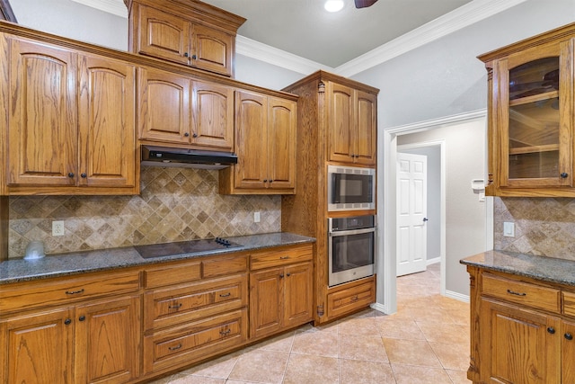 kitchen with stainless steel appliances, light tile patterned floors, dark stone counters, and decorative backsplash