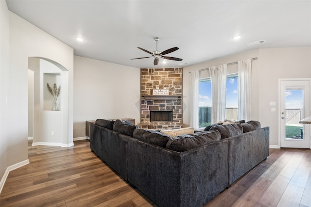 living room featuring ceiling fan, plenty of natural light, and dark wood-type flooring