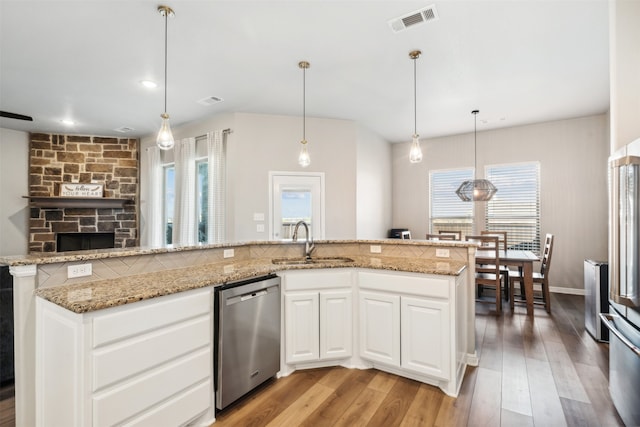 kitchen featuring light wood-type flooring, dishwasher, sink, and plenty of natural light