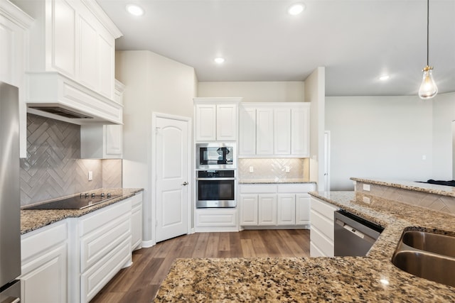 kitchen with white cabinets, tasteful backsplash, decorative light fixtures, hardwood / wood-style flooring, and appliances with stainless steel finishes