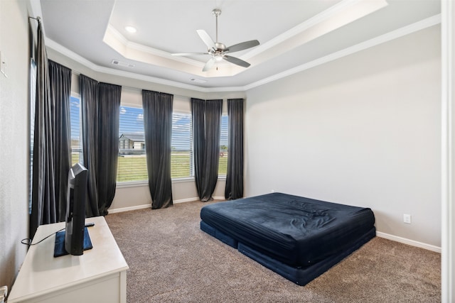 bedroom featuring carpet, a tray ceiling, ceiling fan, and ornamental molding