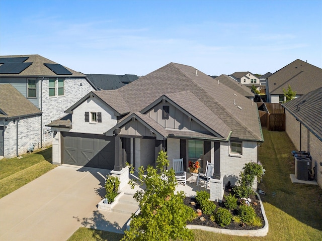 view of front of home with central AC unit, a garage, and a front lawn