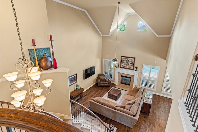 living room featuring wood-type flooring, a tiled fireplace, a chandelier, and a healthy amount of sunlight