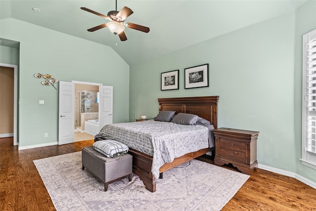 bedroom featuring multiple windows, connected bathroom, lofted ceiling, ceiling fan, and dark hardwood / wood-style floors