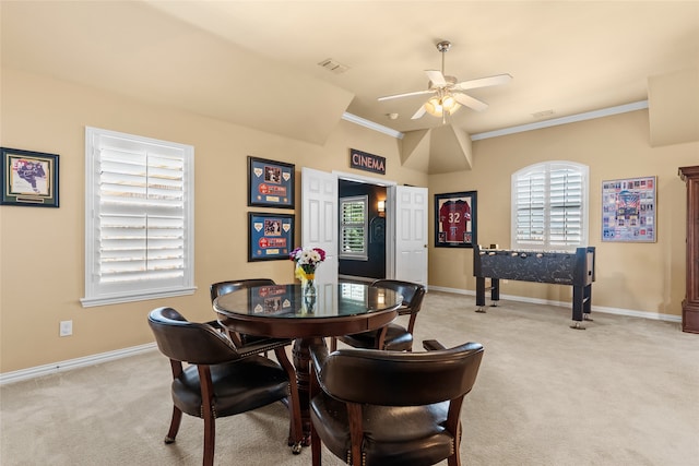 dining space with ornamental molding, ceiling fan, and light carpet