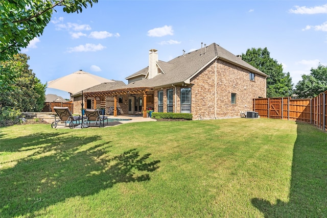 rear view of property with a yard, a patio, and central air condition unit