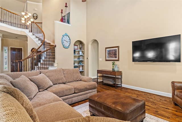 living room featuring an inviting chandelier, hardwood / wood-style flooring, and a high ceiling