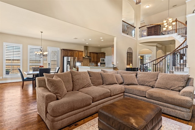 living room featuring a high ceiling, a chandelier, and dark hardwood / wood-style flooring