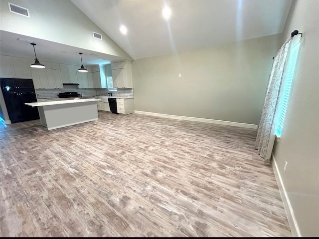 kitchen featuring light hardwood / wood-style floors, tasteful backsplash, a center island, and decorative light fixtures