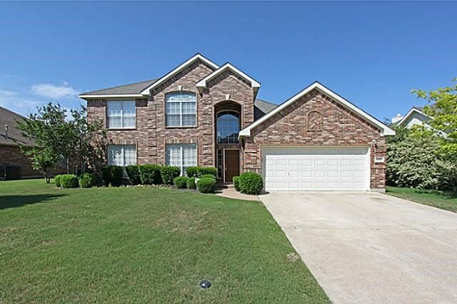 view of front of property with a front lawn and a garage