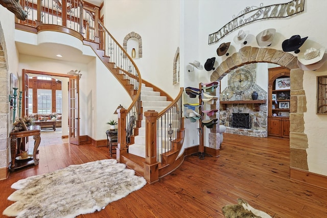 entryway featuring a high ceiling, wood-type flooring, and a fireplace