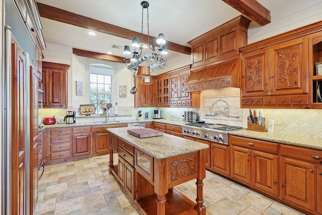 kitchen featuring beam ceiling, a center island, stainless steel gas cooktop, and light stone counters