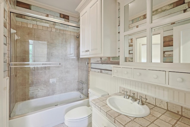 full bathroom with enclosed tub / shower combo, vanity, crown molding, and toilet