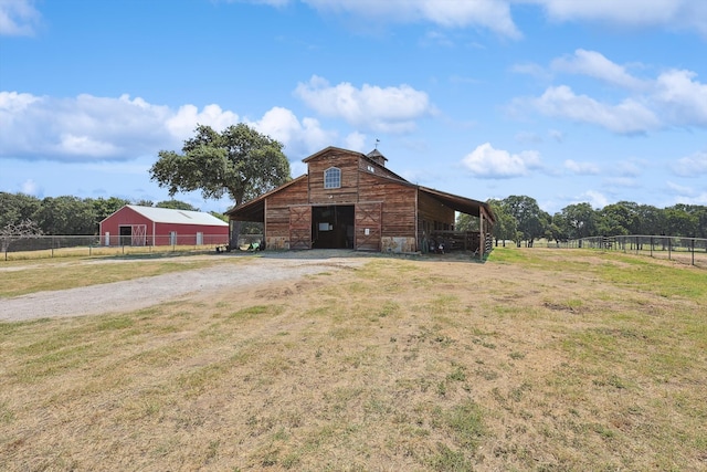 view of outbuilding featuring a rural view and a yard