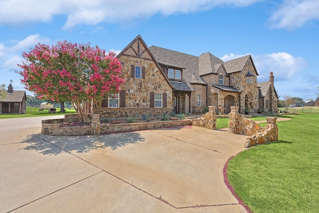 tudor-style house with a front lawn