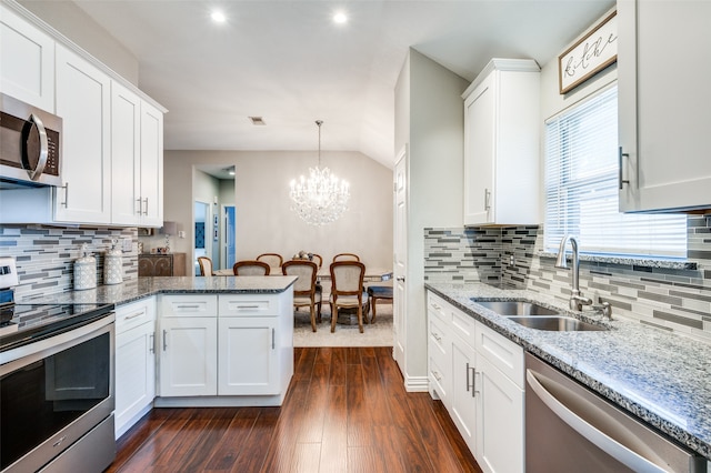 kitchen with appliances with stainless steel finishes, white cabinets, dark hardwood / wood-style floors, sink, and a notable chandelier