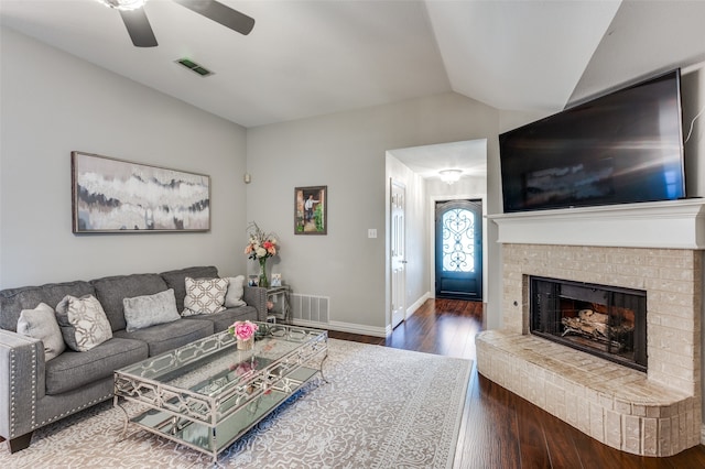 living room featuring a brick fireplace, lofted ceiling, ceiling fan, and hardwood / wood-style flooring