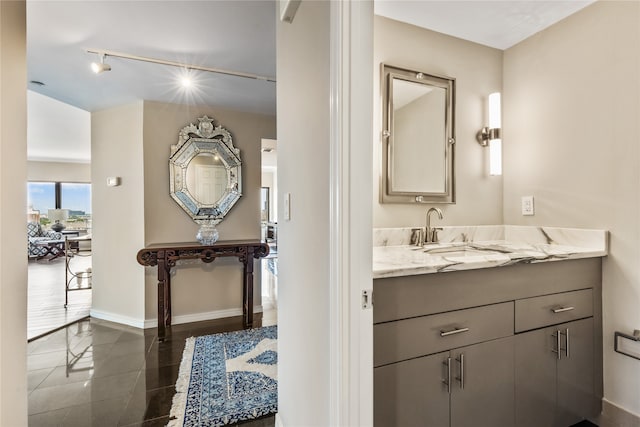 bathroom with rail lighting, vanity, and tile patterned floors