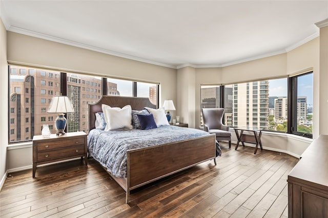 bedroom with ornamental molding, multiple windows, and dark wood-type flooring